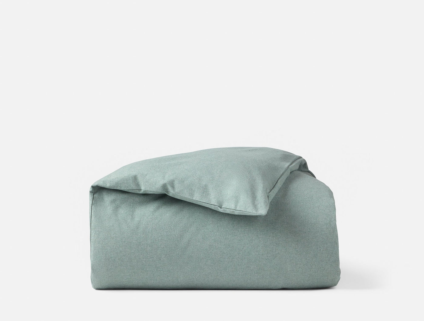 Sage green brushed flannel duvet cover folded and stacked against white background.