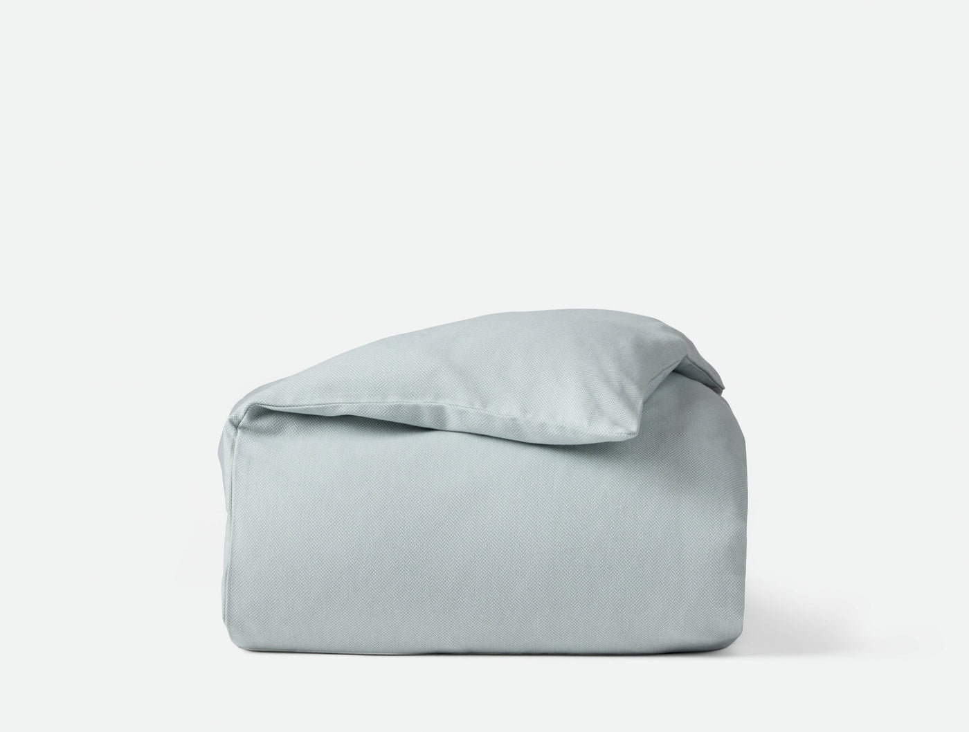 Coyuchi Cloud Brushed Flannel duvet cover folded neatly, pale sage blue-grey tone.