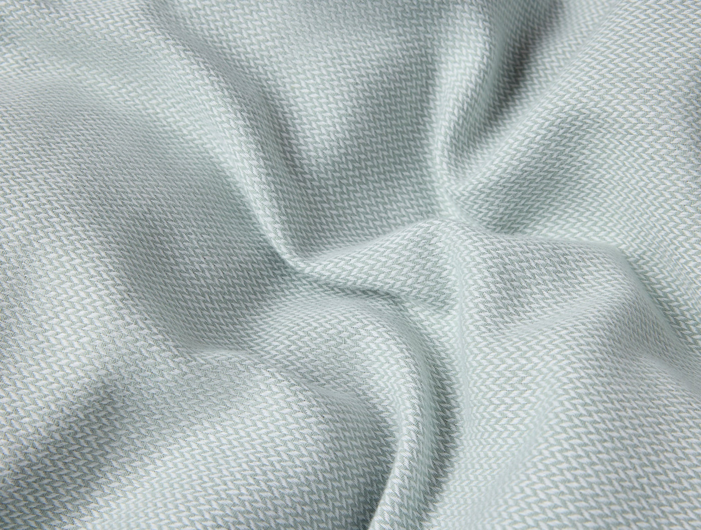 Close-up of pale aqua brushed flannel fabric with soft herringbone weave texture and gentle draping.