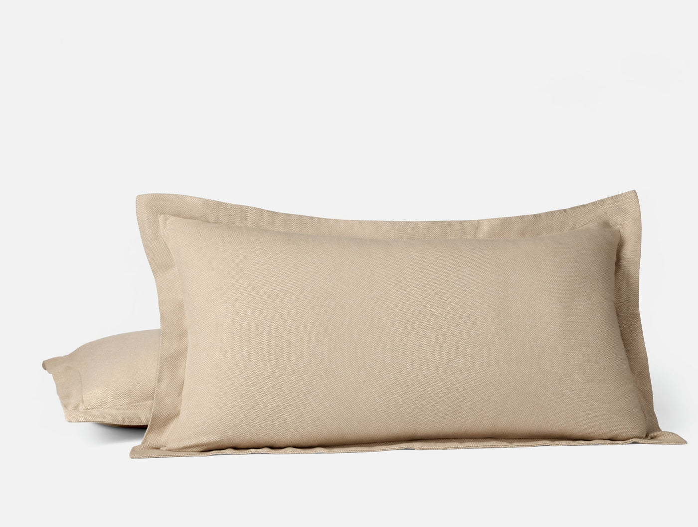Close-up of Coyuchi Cloud Brushed Flannel pillow shams in natural tan, showing flange edge detail.