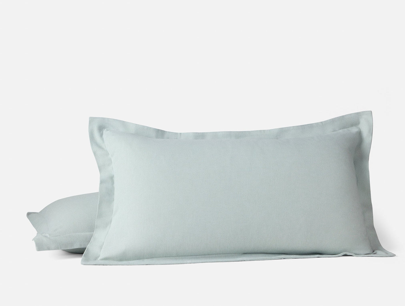Pale aqua flannel pillow sham with wide flange border, stacked pair on white background.