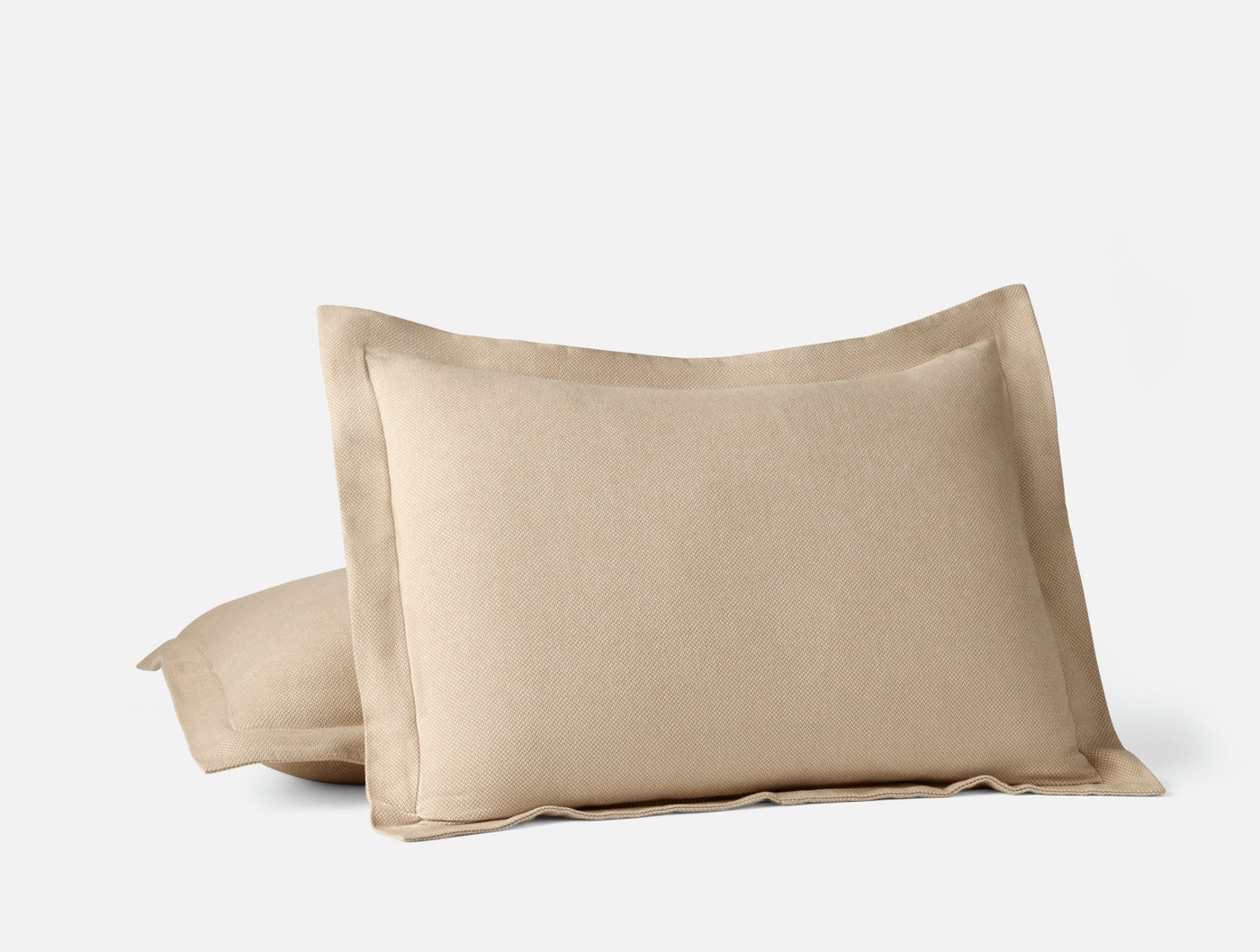 Close-up of Coyuchi Cloud Brushed Flannel pillow shams in warm sand with flanged edges.
