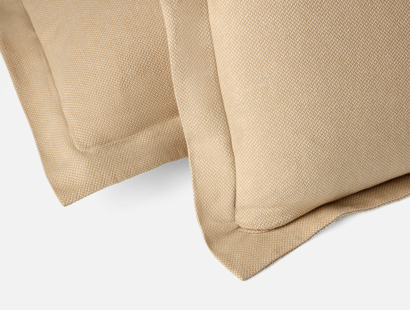 Close-up of Coyuchi Cloud Brushed Flannel sham corners in honey, showing textured weave and flange detail.