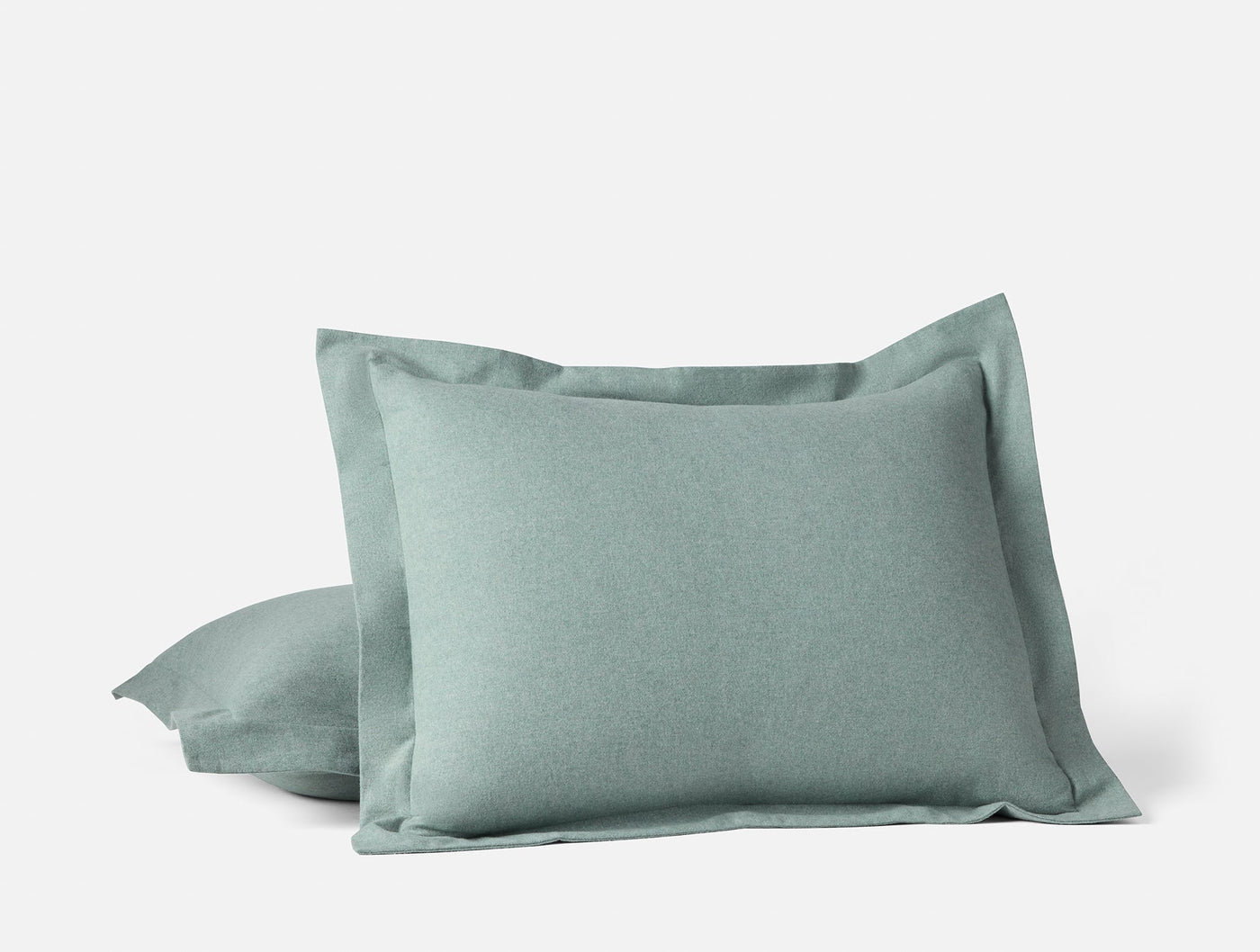 Close-up of two sage Cloud Brushed Flannel shams stacked, showing flanged edge detail.