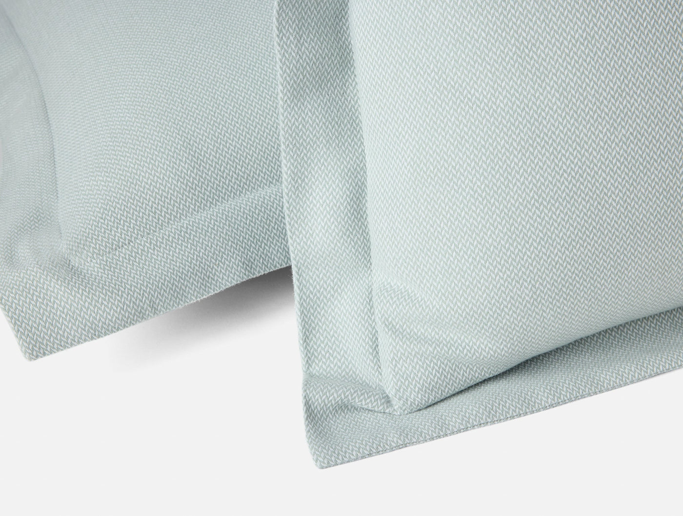 Close-up of Coyuchi Cloud Brushed Flannel sham in seafoam, showing woven texture and border detail.