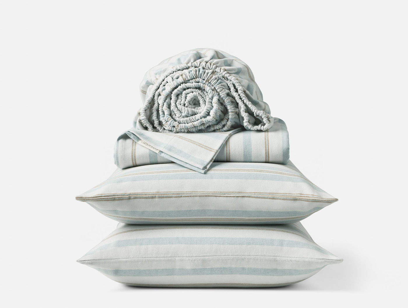 Close-up of stacked Coyuchi Cloud Brushed Flannel sheet set in pale aqua stripe with rolled fitted sheet on top.