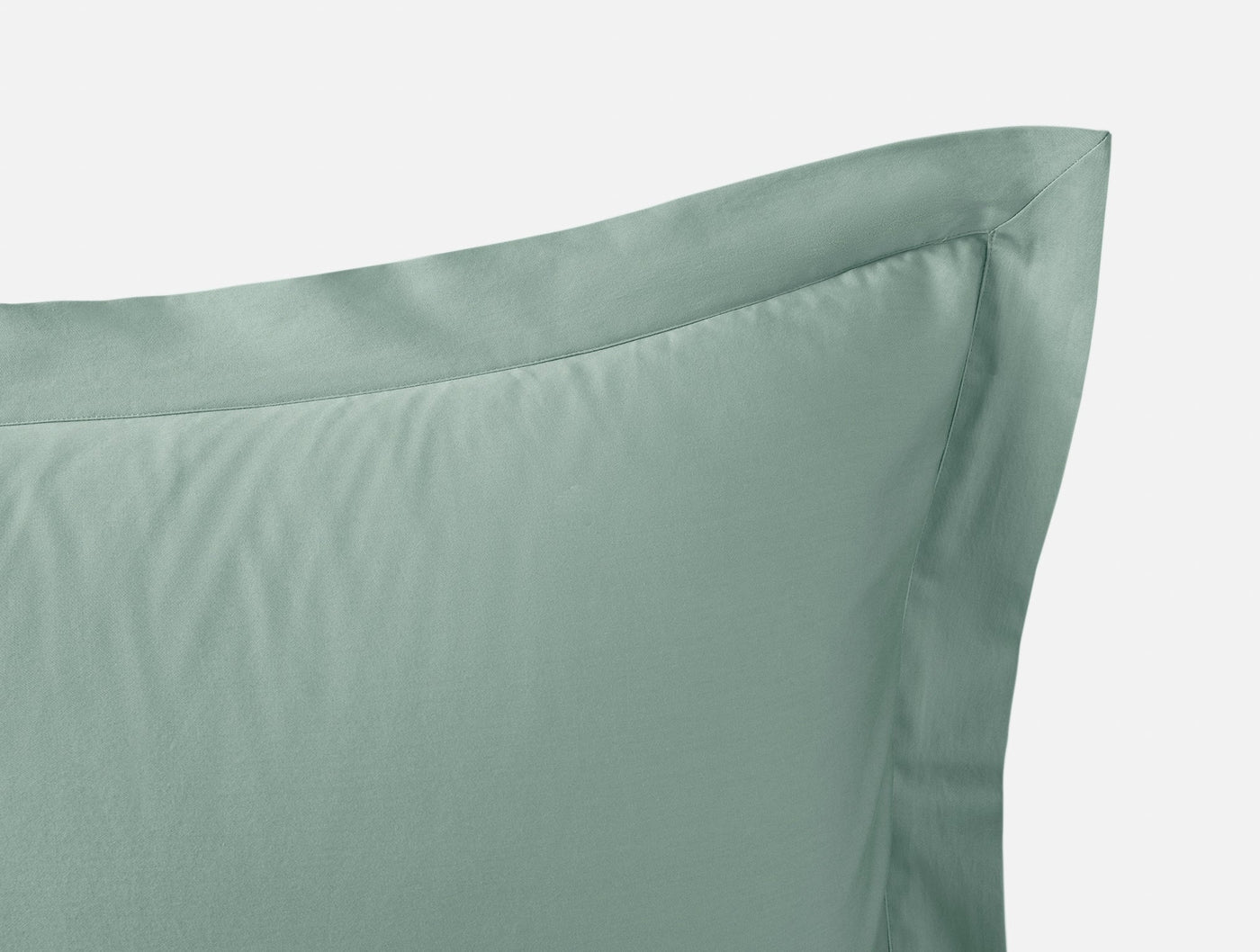 Close-up of Coyuchi Cloud Soft Sateen pillow sham corner in sage, showing flange detail.