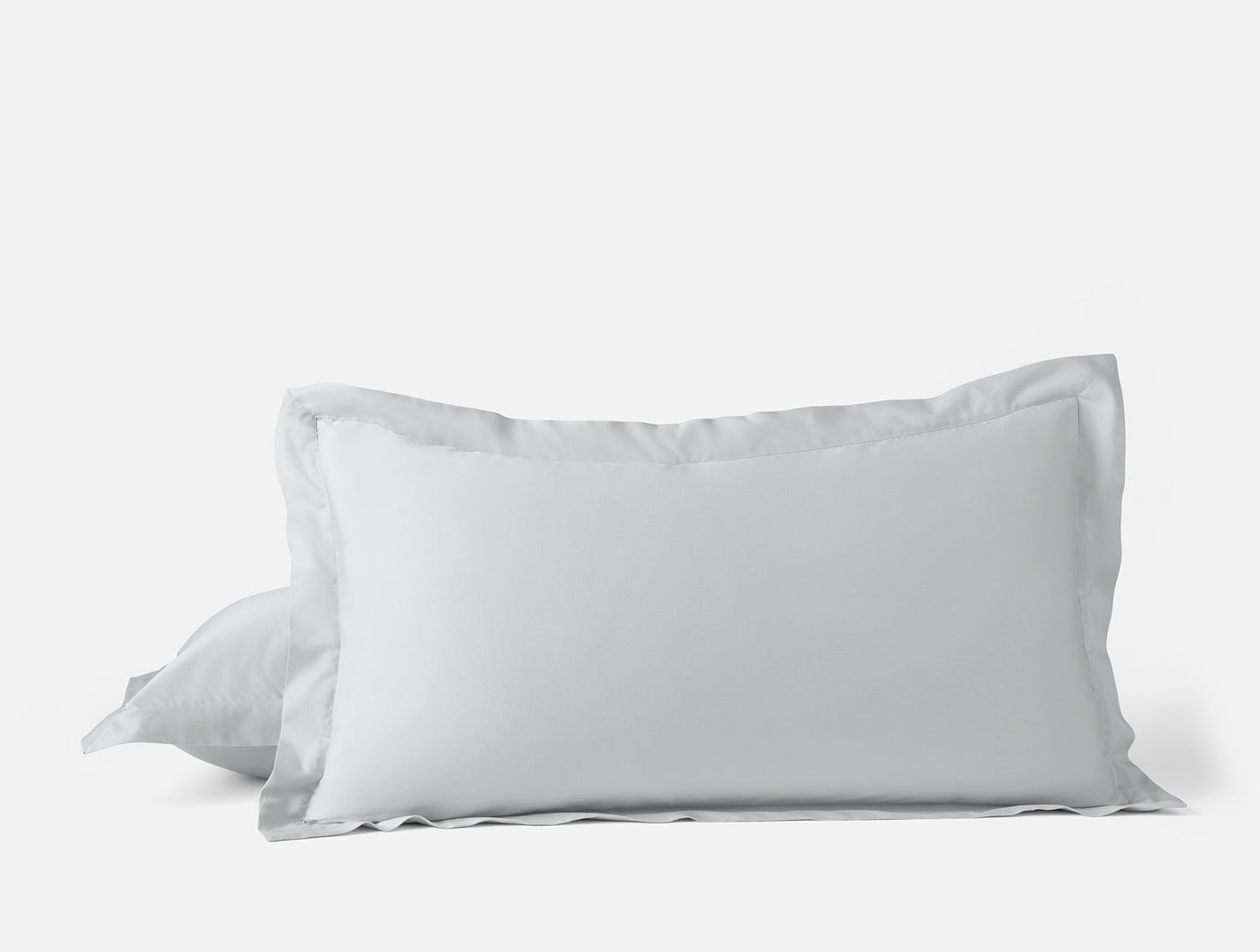 Close-up of two white Coyuchi Cloud Soft Sateen pillow shams stacked against a white background.