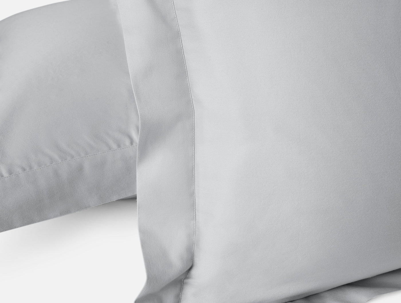 Close-up of Coyuchi Cloud Soft Sateen pillow shams in silver grey with smooth sateen finish.
