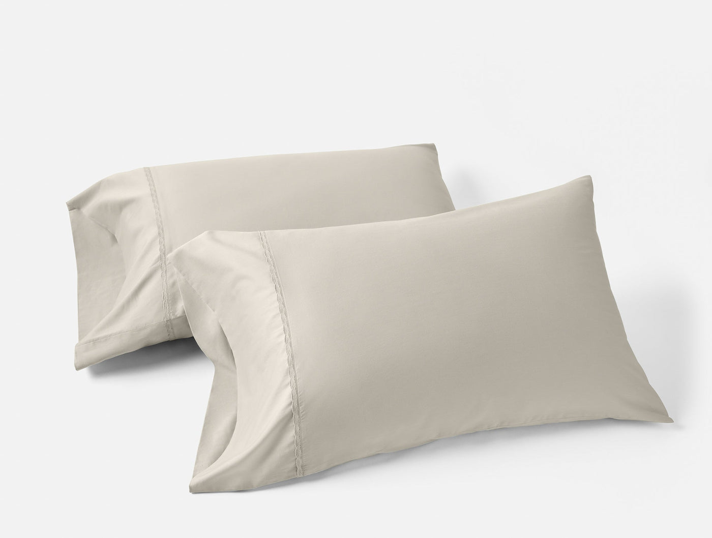 Two Coyuchi Cloud Soft Sateen pillowcases in stone, stacked at an angle on white background.
