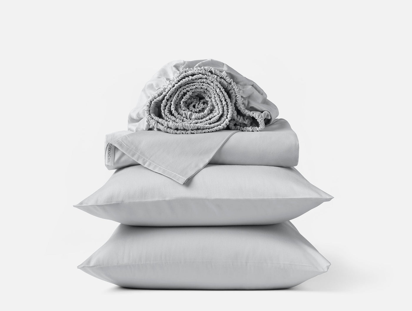 Stacked silver grey sateen sheet set with rolled fitted sheet atop folded flat sheet and two pillowcases.