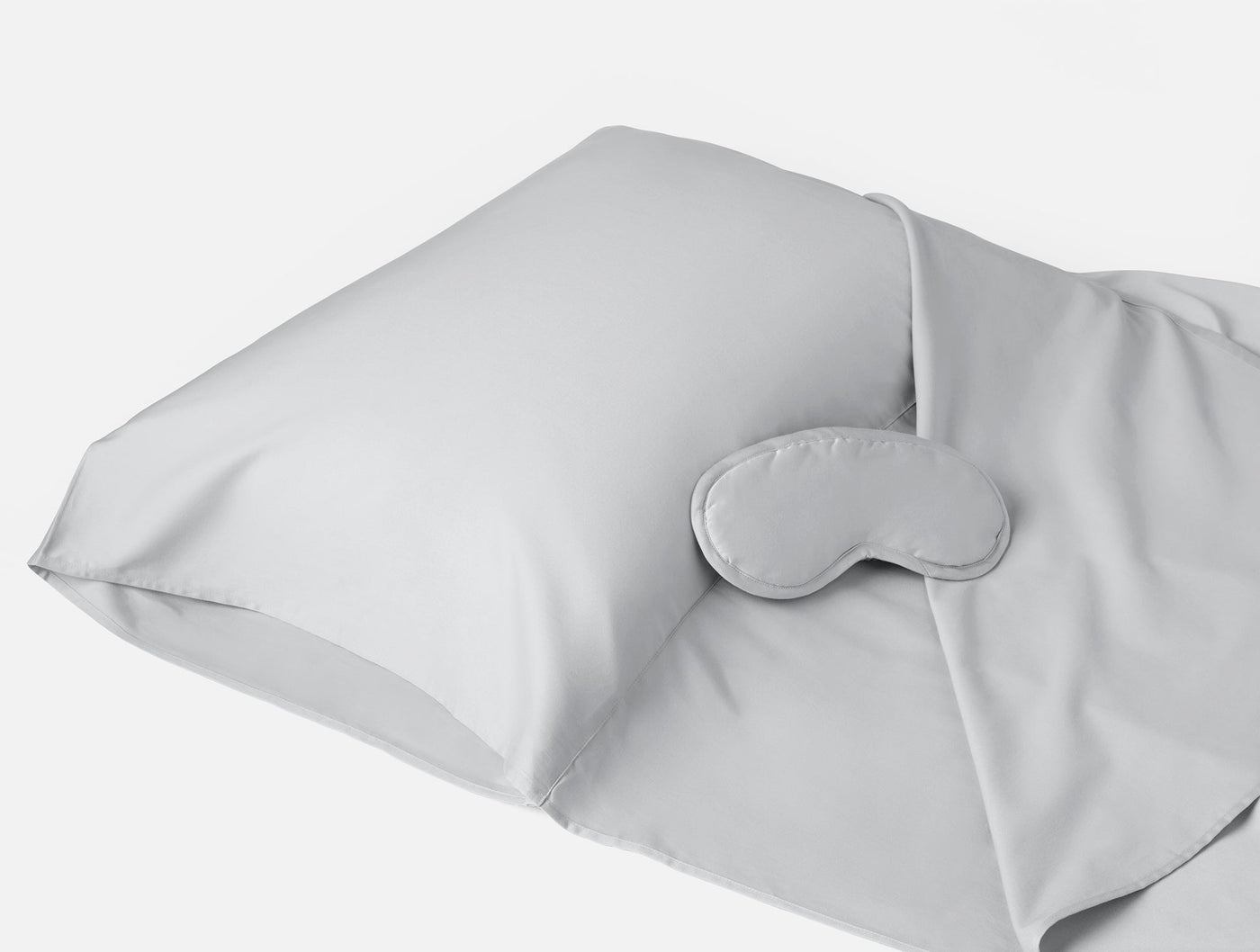 Coyuchi Cloud Soft Sateen travel sack in silver with matching sleep mask, angled view.