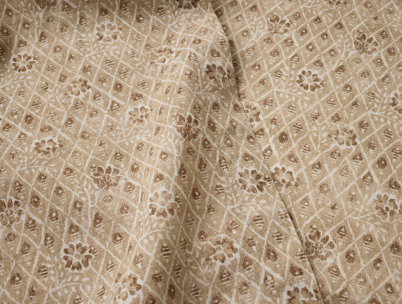 Close-up of Coyuchi Coral Bell Print runner in taupe, floral diamond lattice pattern.