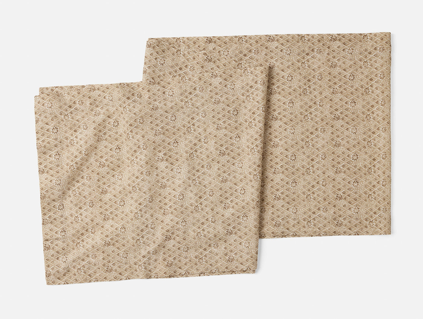 Two Coyuchi Coral Bell Print table runners in sand, showing geometric pattern detail.