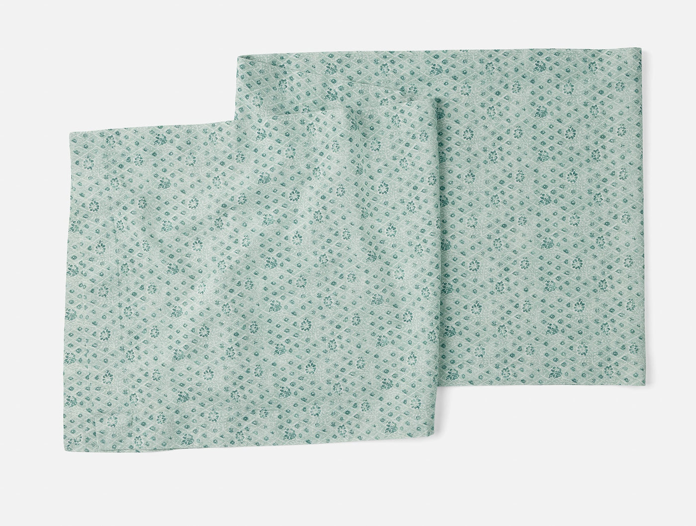 Close-up of Coyuchi Coral Bell Print runner in seafoam with scattered floral motifs.