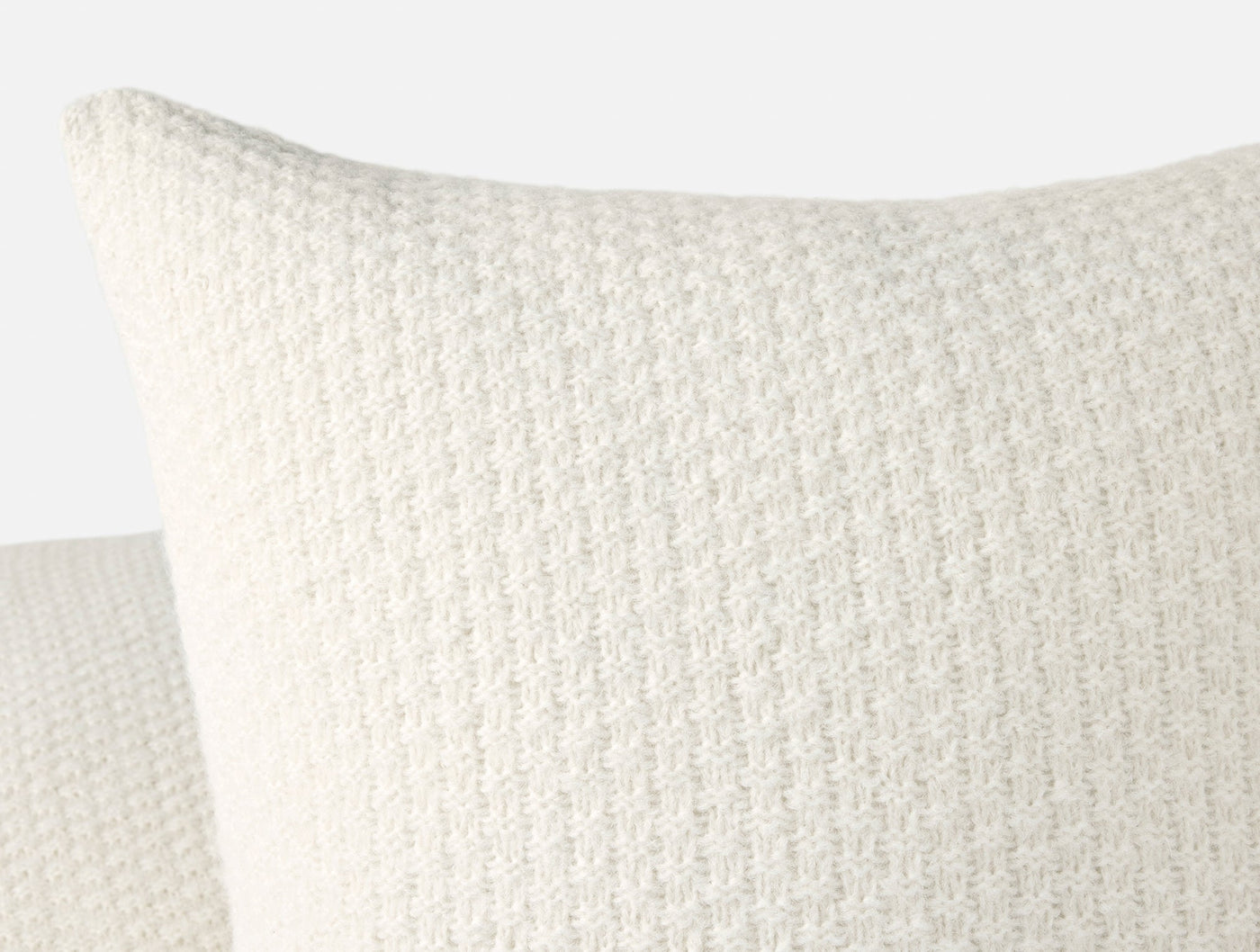 Close-up of ivory alpaca cotton knit texture on Cordillera pillow corner and edge detail.