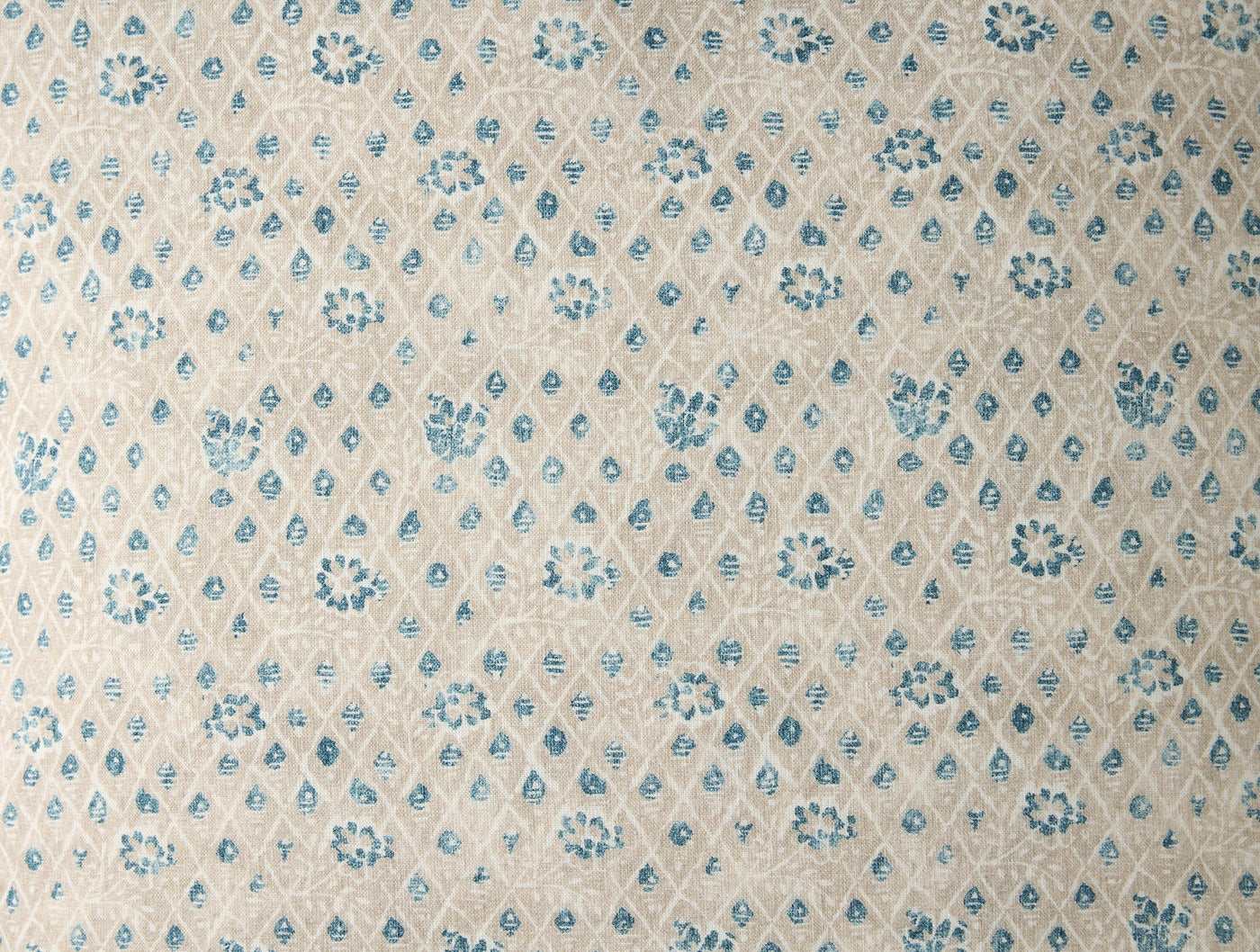 Close-up of Coyuchi Coral Bell Print fabric in blue floral diamond pattern on ivory.