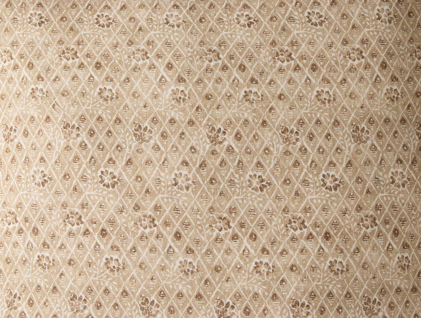Close-up of Coyuchi Coral Bell Print pillow cover, champagne diamond lattice with floral motifs.