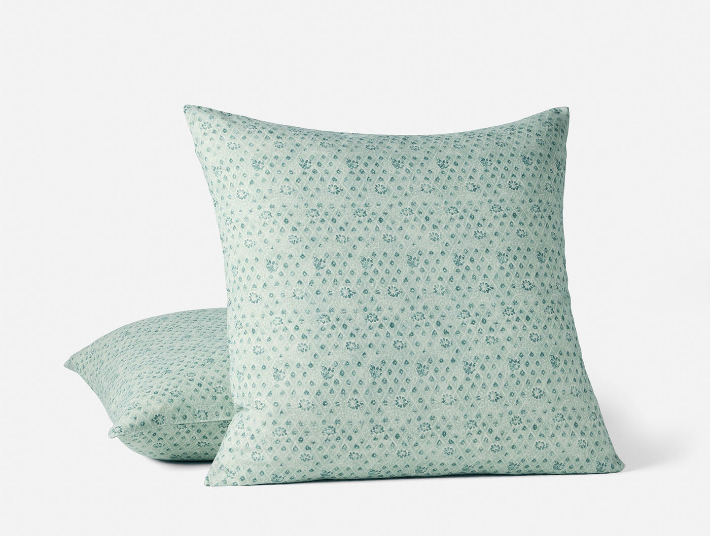 Coyuchi Coral Bell Print pillow covers in sage green, small floral dot pattern, two sizes shown.