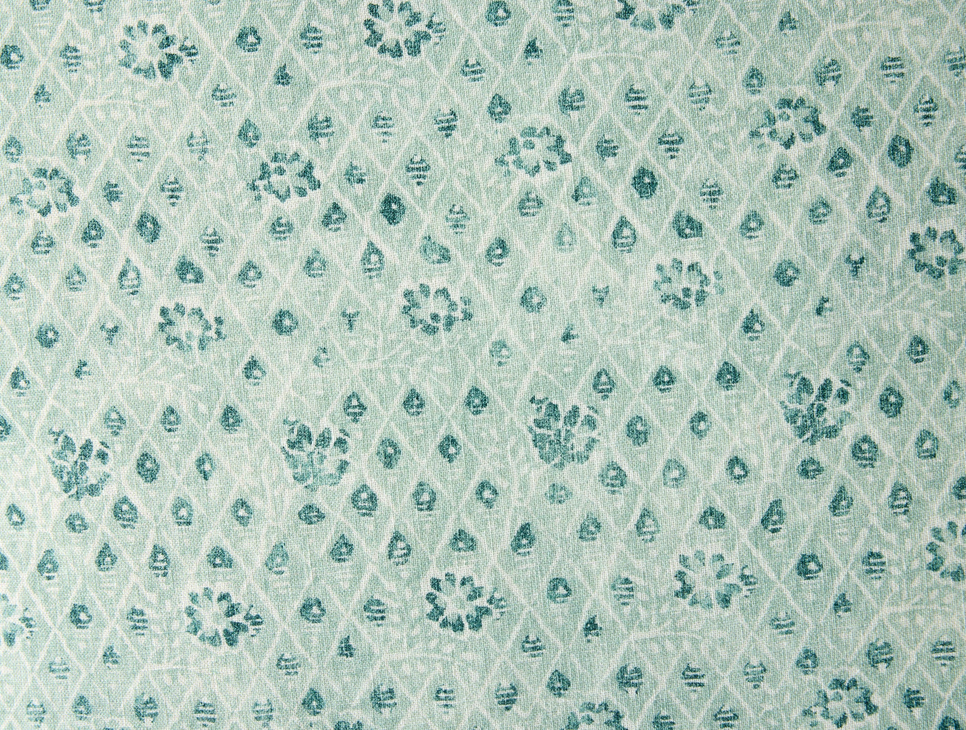 Close-up of teal floral and diamond lattice print on seafoam cotton fabric.