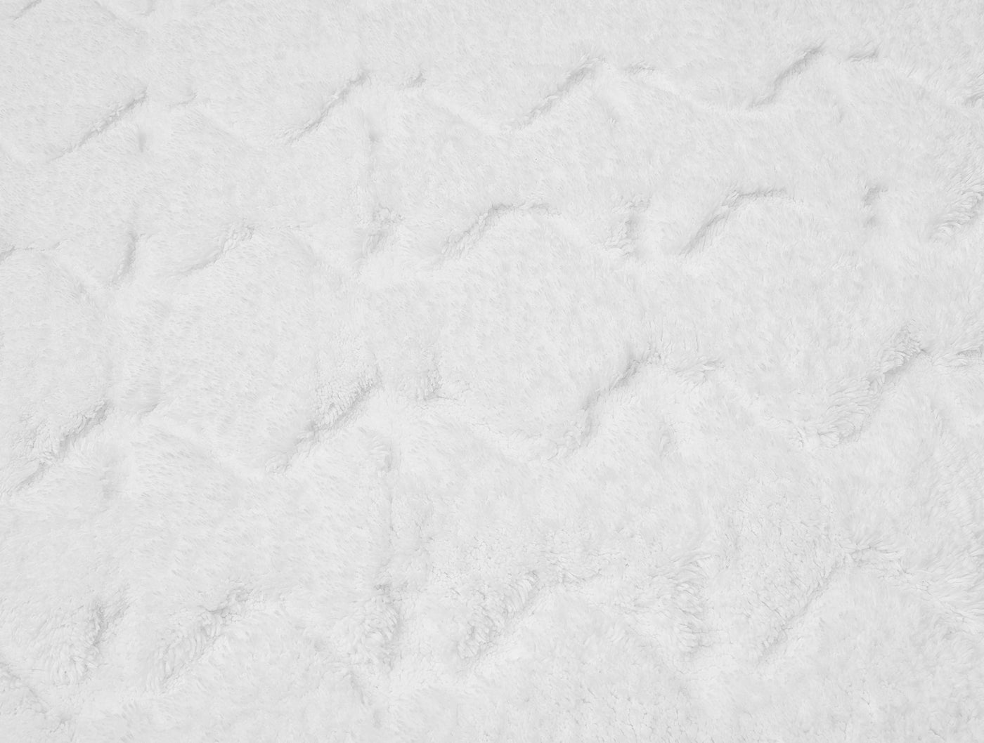 Close-up of white diamond-pattern shag texture on Coyuchi bath rug.