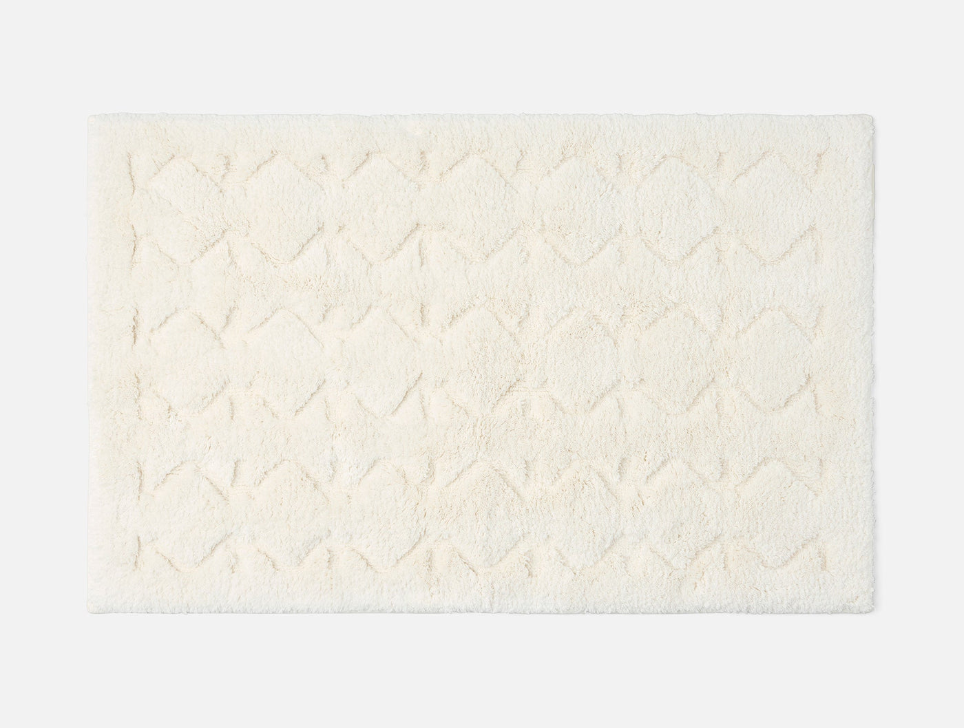 Coyuchi Diamond Shag bath rug in ivory, overhead view showing tufted diamond pattern texture.
