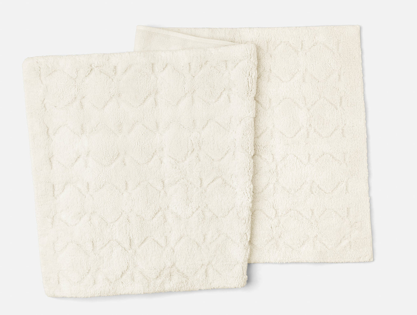 Reverse side of Coyuchi Diamond Shag bath rugs showing ivory textured weave pattern.