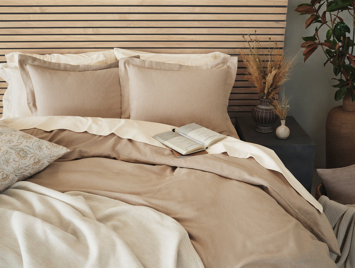 Camel and ivory flannel shams styled on a made bed with coordinating duvet.