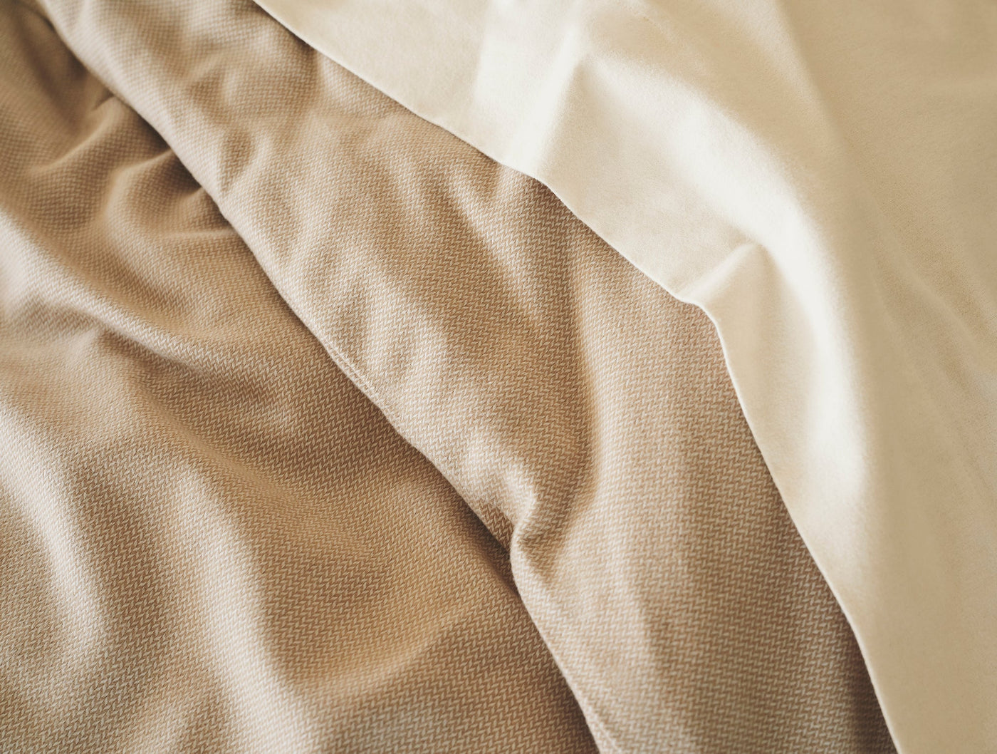 Close-up of brushed flannel layers in warm taupe and ivory tones showing soft texture.