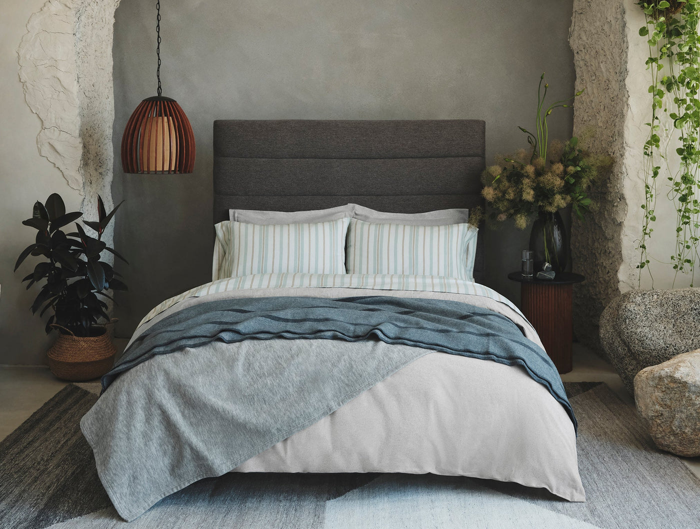 Coyuchi Cloud Brushed Flannel shams styled on bed with striped bedding in muted blue tones.