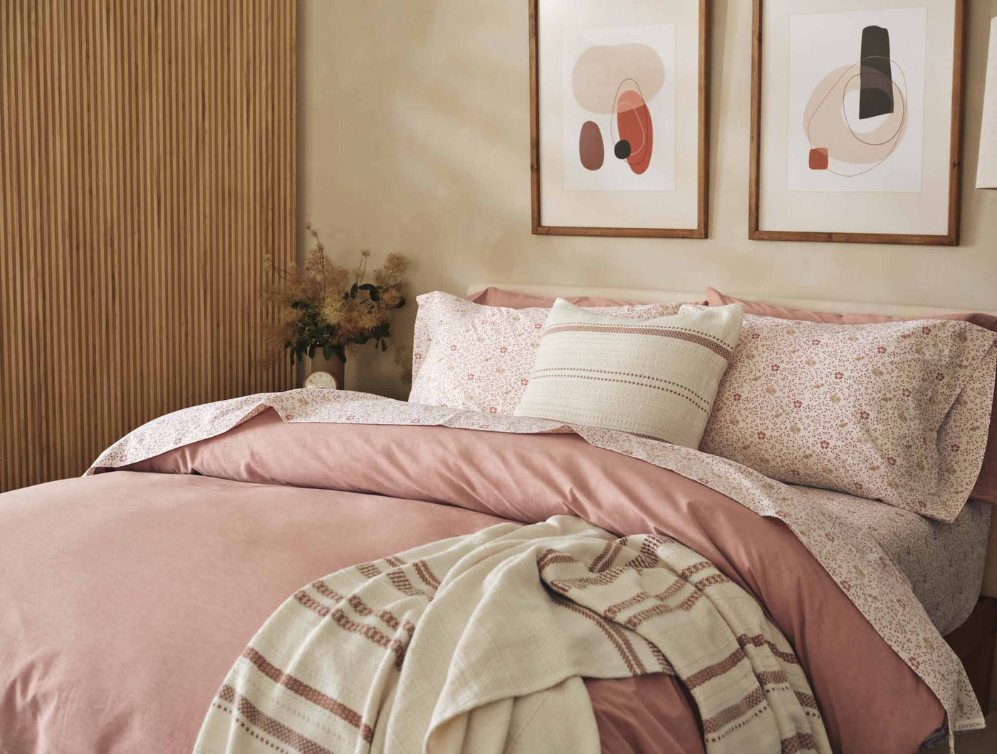 Coyuchi Print Percale sheet set styled in rose bedroom with floral pillows and woven throw.