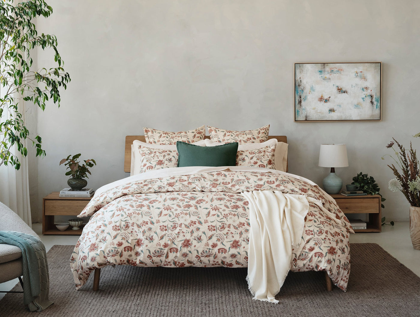 Coyuchi Viola Print sham styled on a made bed with floral duvet in a neutral bedroom.