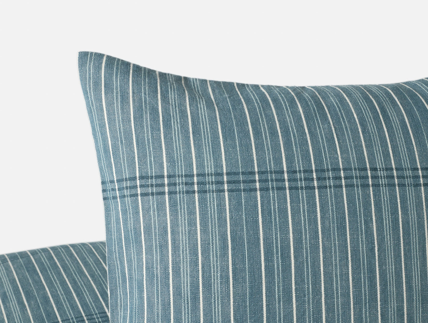 Close-up of Coyuchi Fernwood pillow corner showing teal and ivory stripe pattern.