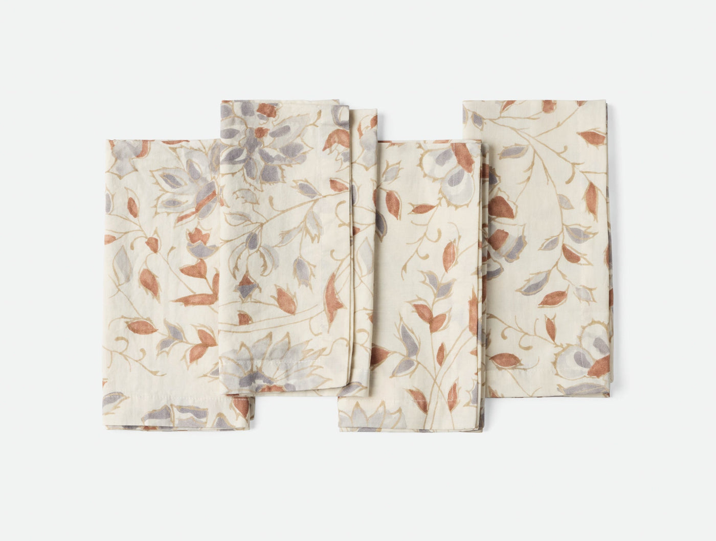 Coyuchi Flora Print napkin set in ivory with rust and grey botanical print, fanned flat lay.