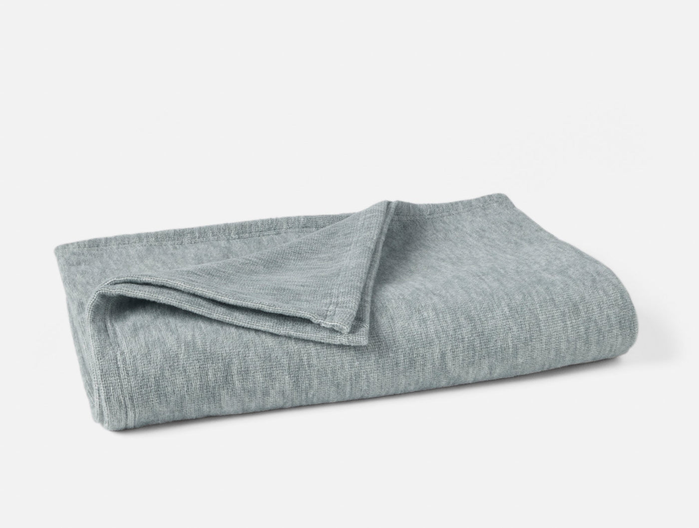 Coyuchi Full Circle Cotton throw in muted sage, folded to show soft heathered knit texture.