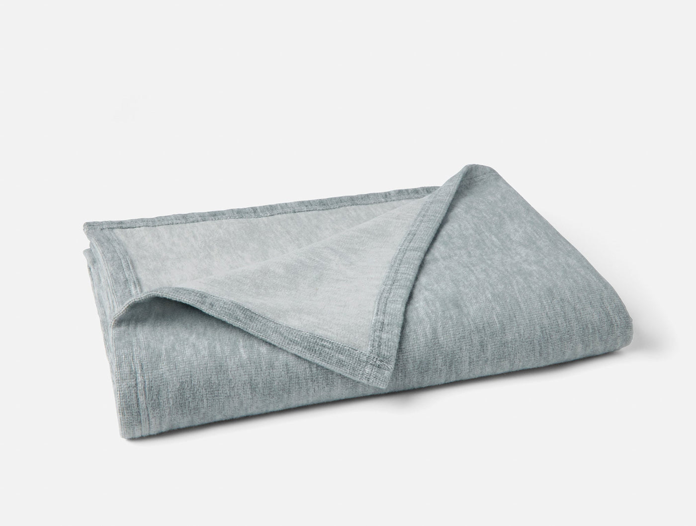 Coyuchi Full Circle Cotton throw folded, showing mist blue reverse side and hem detail.