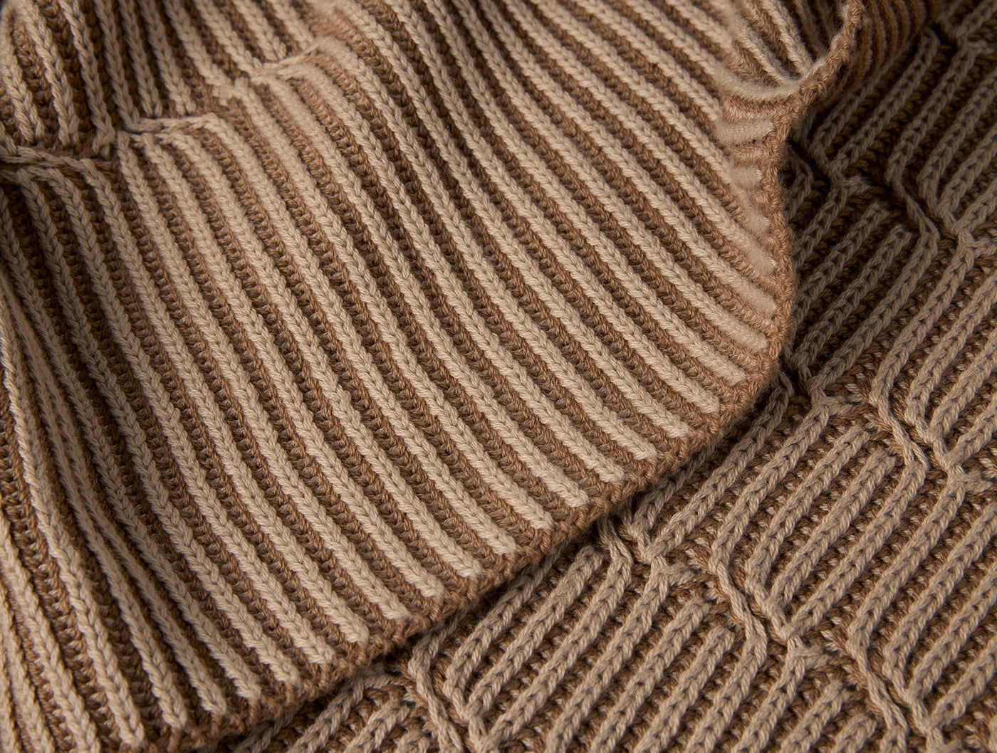 Close-up of Coyuchi Ivy Knit throw showing ribbed and honeycomb textures in warm camel tones.