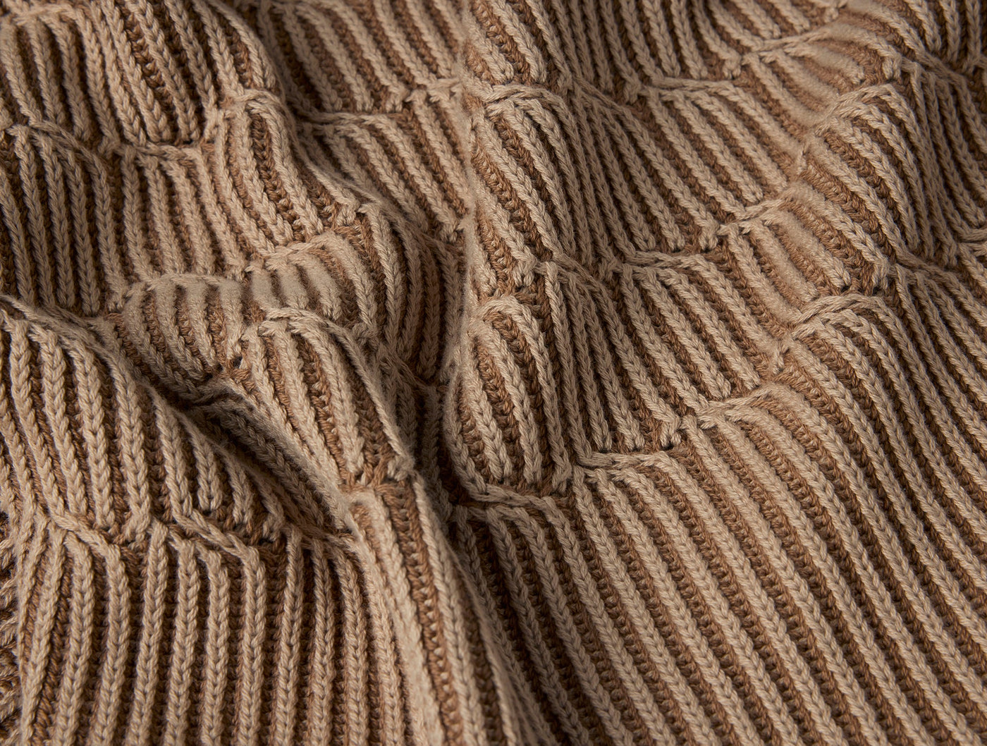 Close-up of Coyuchi Ivy Knit throw in camel, showing raised bubble texture over ribbed weave.