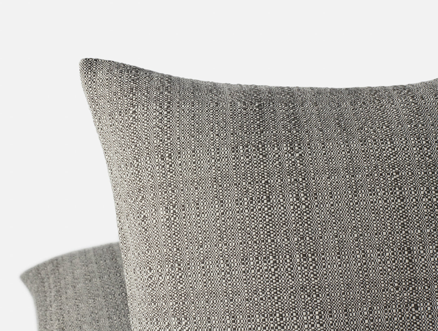 Close-up of Coyuchi Lido pillow cover corner showing charcoal nubby woven texture.