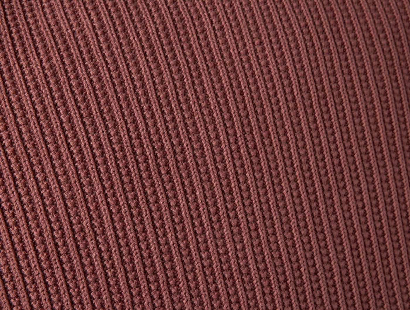 Close-up of Coyuchi Linea Knit pillow cover showing ribbed texture in terracotta.