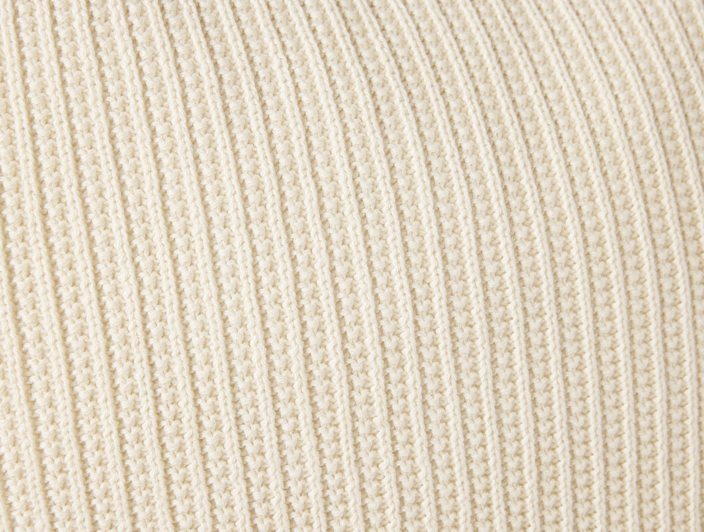 Close-up of Coyuchi Linea Knit pillow in ivory, showing ribbed knit texture detail.