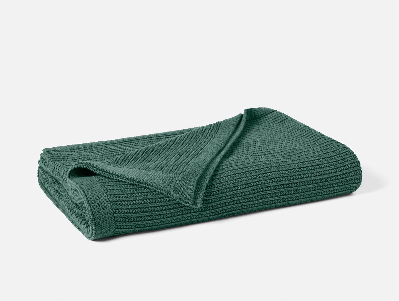 Folded forest green knit throw, showing ribbed texture and corner detail.