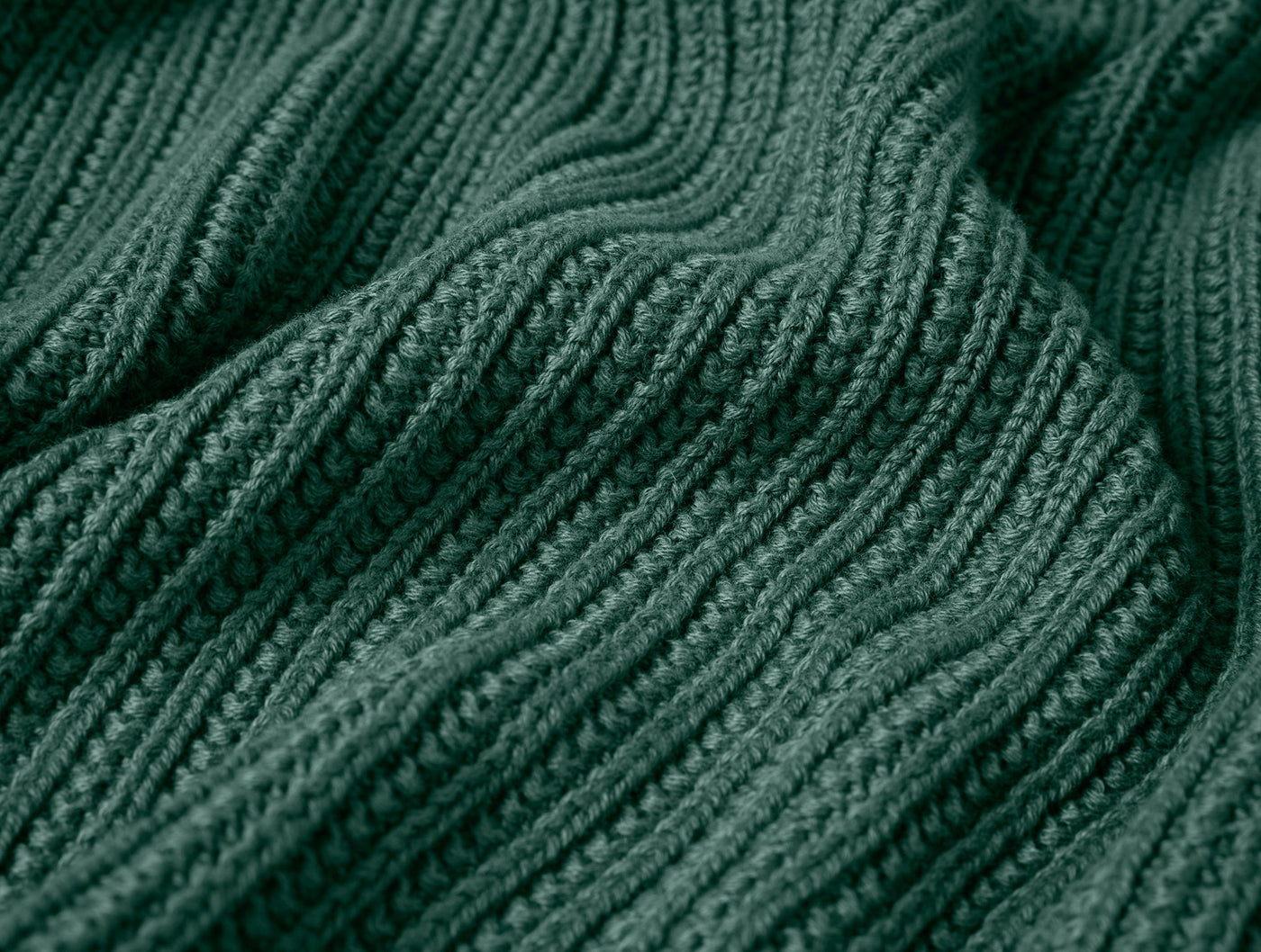 Close-up of forest green ribbed knit texture on the Linea Throw, showing soft drape.