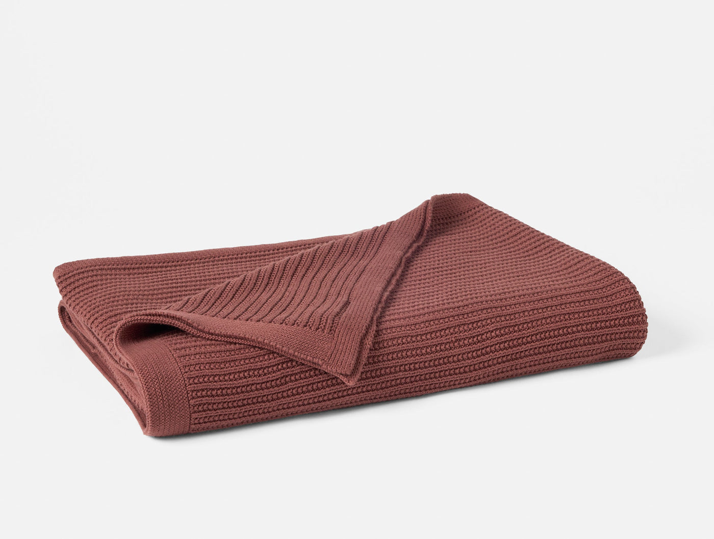 Folded dusty rose Coyuchi Linea Knit throw showing ribbed texture detail.