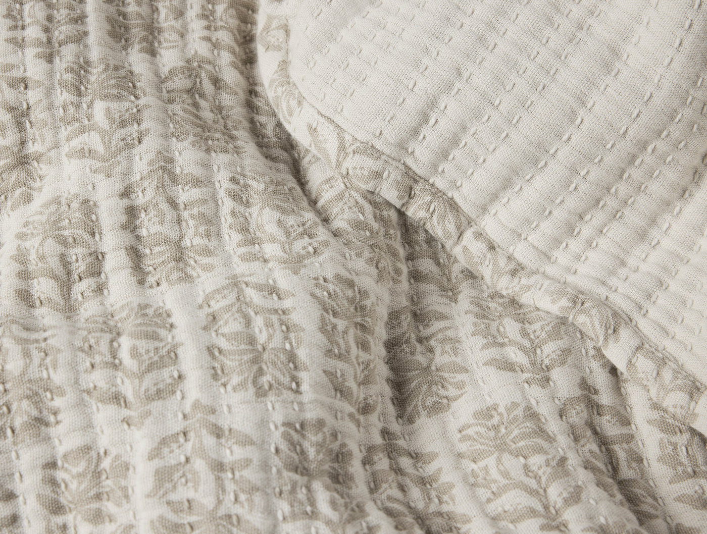 Close-up of Coyuchi Mirada Matelasse blanket reverse, showing ivory quilted texture.