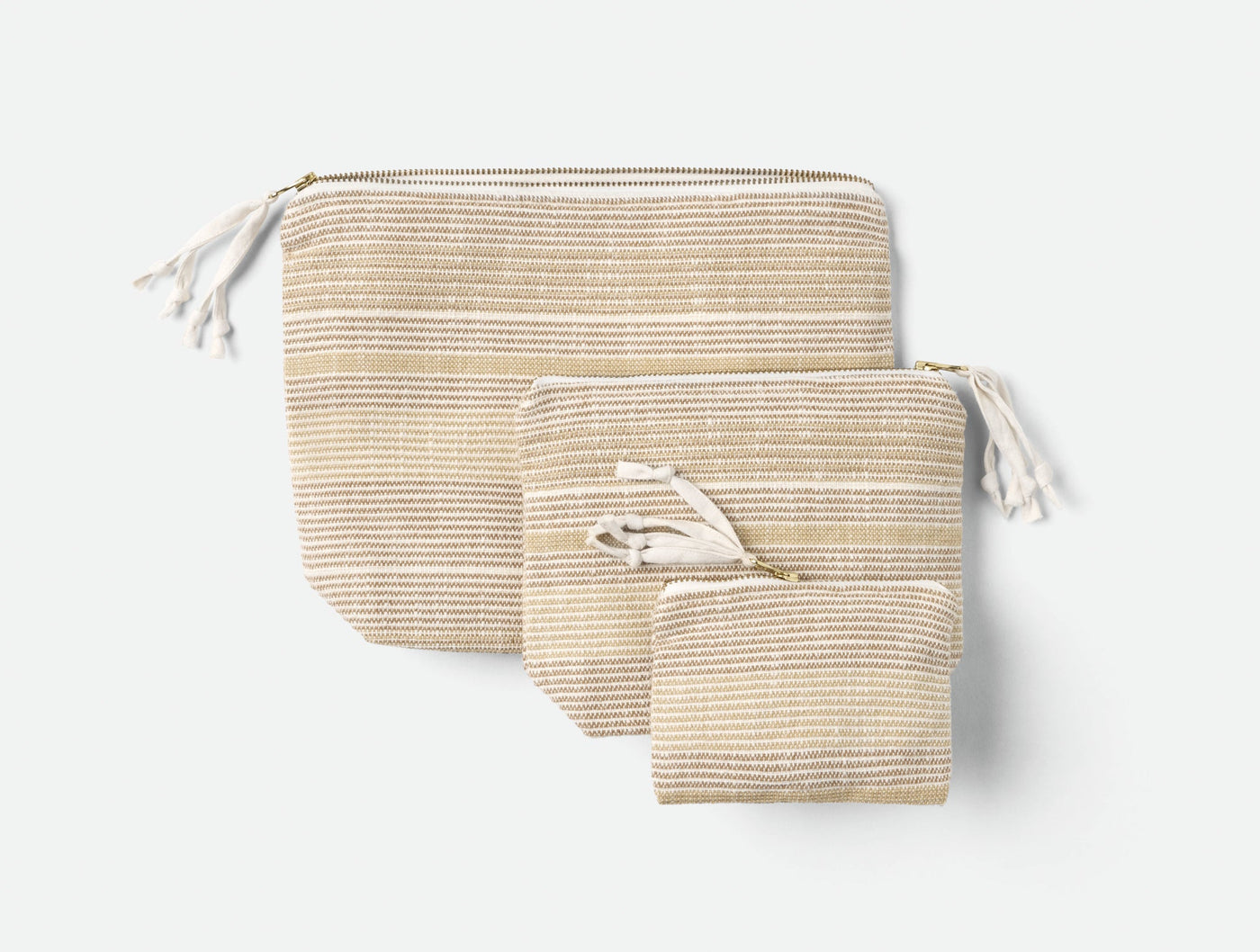 Coyuchi Miraloma pouch set of three in natural stripe, graduated sizes with tassel zippers.