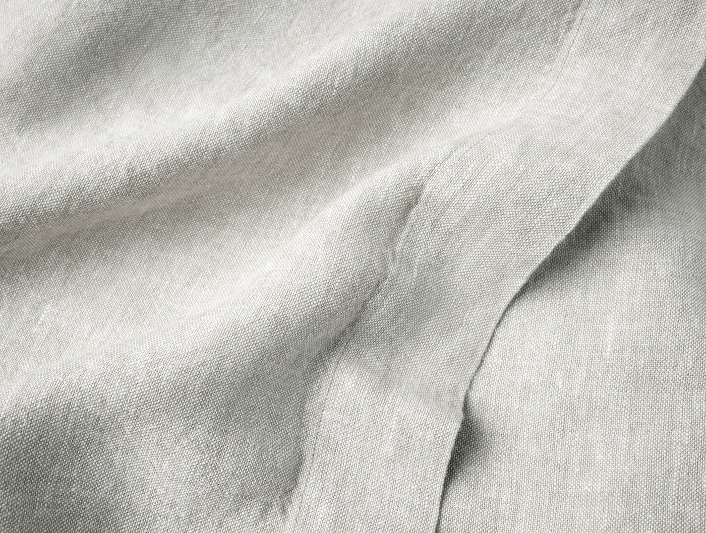 Close-up of Coyuchi Mojave linen table runner in natural, showing soft drape and woven texture.