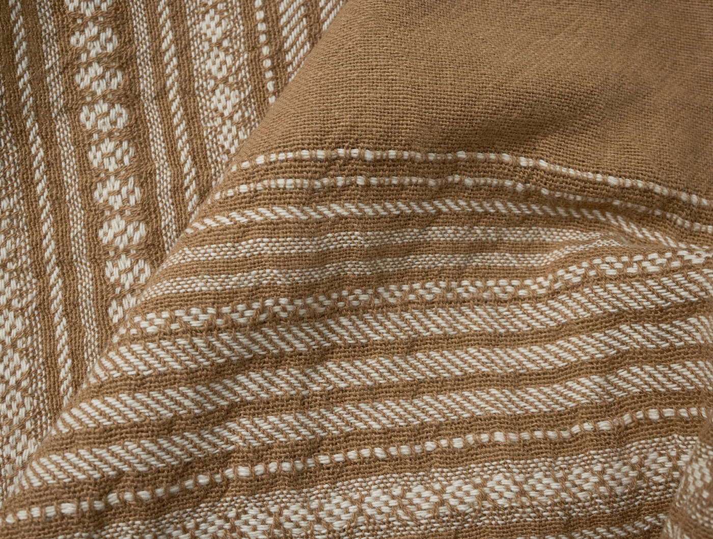 Close-up of Coyuchi Oak hand towel corner showing woven stripe border detail in camel and ivory.