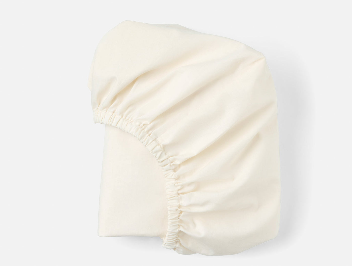 Ivory crinkled percale fitted sheet folded to show elasticized corner detail.