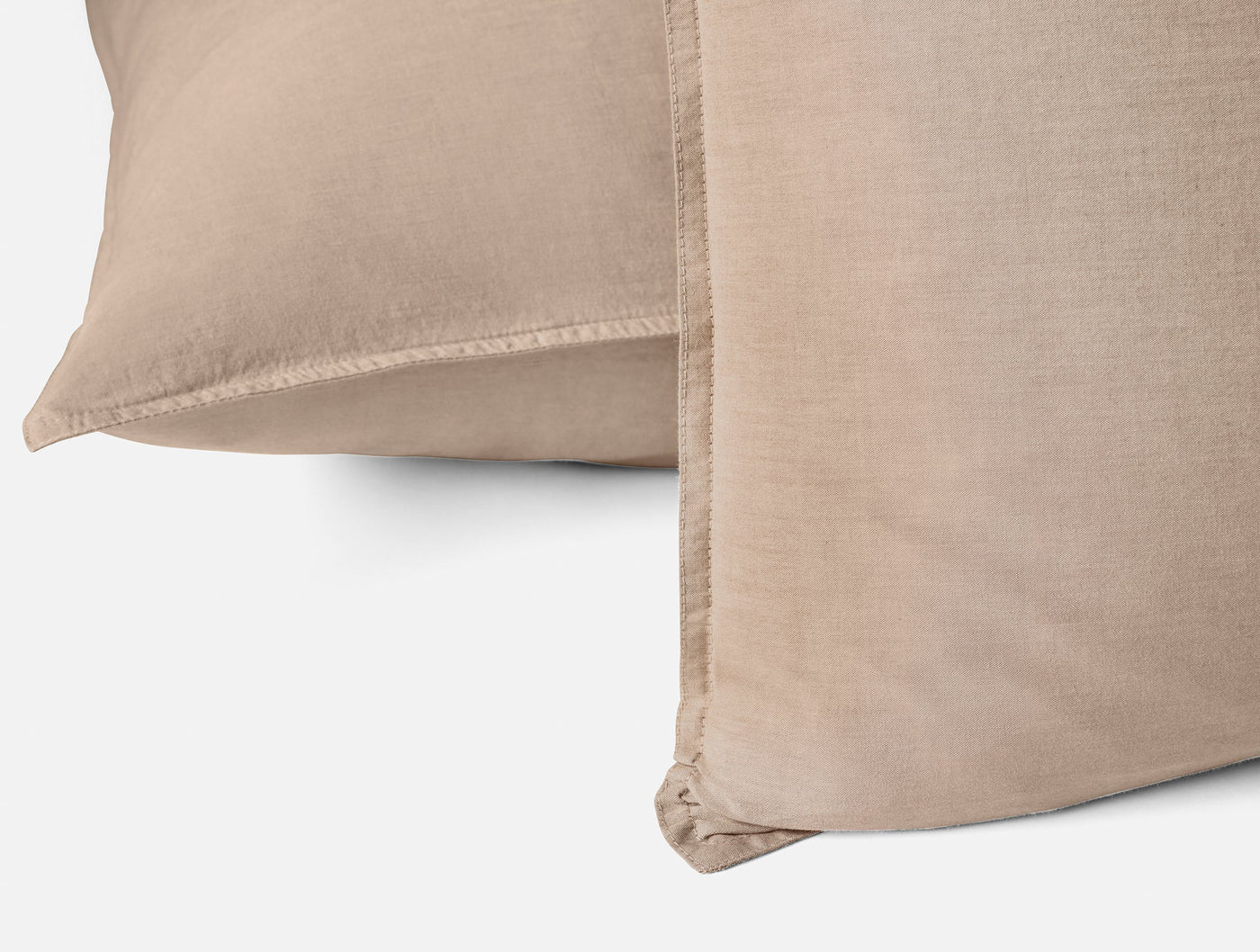 Close-up of two stacked Coyuchi Crinkled Percale shams in warm taupe, showing hem detail.